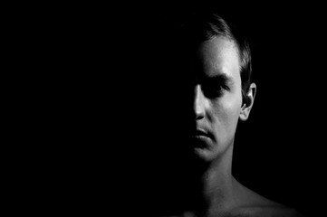 Dramatic portrait of a guy on a black background, black and white photography - 255795207