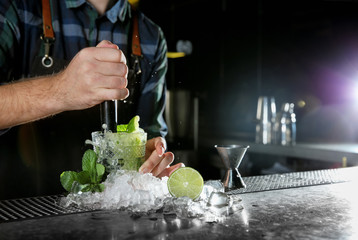Barman making Mojito cocktail at counter in pub, closeup. Space for text - obrazy, fototapety, plakaty