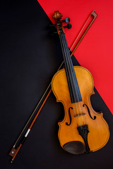 Fototapeta na wymiar Violin and bow on a red and black background