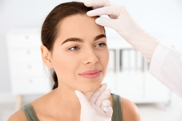 Dermatologist examining patient's face in clinic. Skin cancer checkup