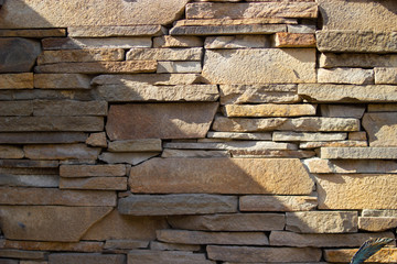 Yellow brick wall with a diagonal shadow