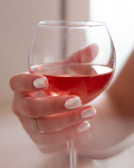 A glass of rose wine in the hand of a girl