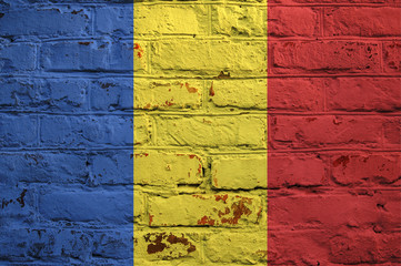 Romanian flag on brick wall background.