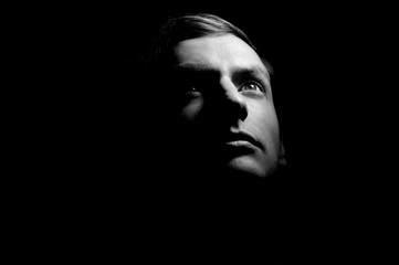 Dramatic portrait of a guy on a black background, black and white photography - 255796476