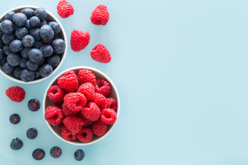 Forest fruit, delicious berries, pastel blue glass background with space for text