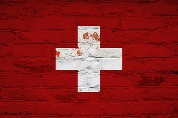 Swiss flag on brick wall background. Background wallpaper for installation and design. Space for...