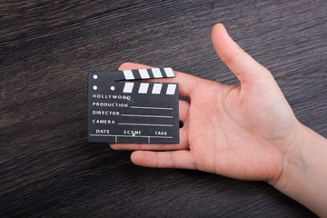Hand holding a little movie  clapper in hand