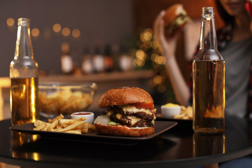 Tasty burger and french fries served on table in cafe