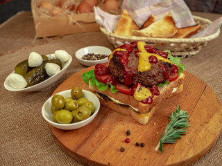 Toast with beef Patty, cucumbers, tomatoes and olives.