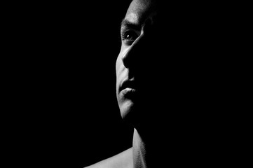 Dramatic portrait of a guy on a black background, black and white photography - 255797890