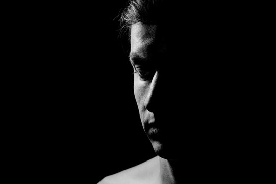 Fototapeta Dramatic portrait of a guy on a black background, black and white photography