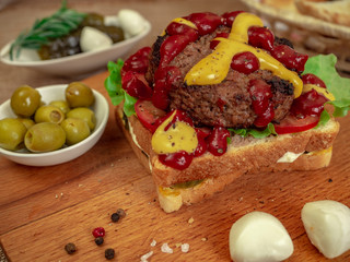Toast with beef Patty, cucumbers, tomatoes and olives.