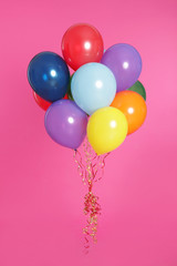 Bunch of bright balloons on color background