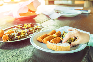 Grilled vegetables and potato croquettes, Croatian national food, vegetarian. Hand of a child taking bread.