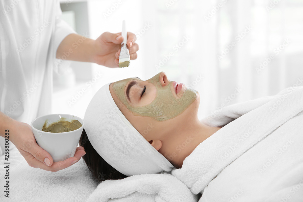 Poster Cosmetologist applying mask on client's face in spa salon