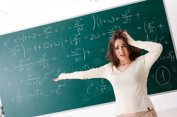 Young female math teacher in front of chalkboard  