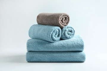 Stack of fresh fluffy towels on grey background