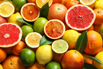 Different citrus fruits as background, top view