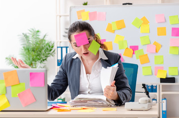 Young female employee in conflicting priorities concept 