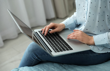 Blogger working with modern laptop at home, closeup