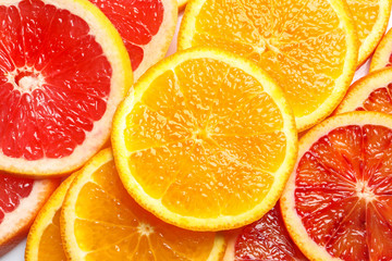 Fototapeta na wymiar Slices of fresh citrus fruits as background, top view
