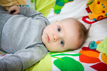 Newborn child relaxing in bed. Nursery for young children.