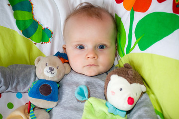 Newborn child relaxing in bed. Nursery for young children.
