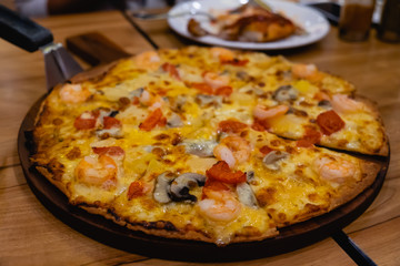 Shrimp cocktail pizza on wooden plate