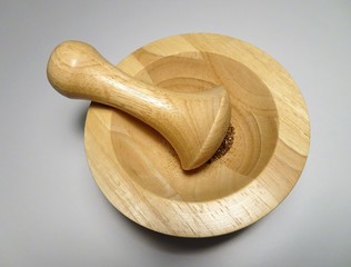 Mörser und Stößel aus Holz vor weißem Hintergrund