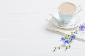 Drink from chicory in a cup on the white wooden table