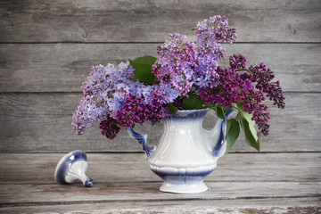 Still life with a blooming branch of lilac