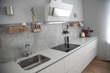 working area of white kitchen with sink, hob, coffee machine