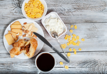 Healthy breakfast with cereal and feta cheese, a cup of coffee and sandwiches