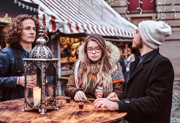 Young tourists relaxing with drinks on the market of the city square