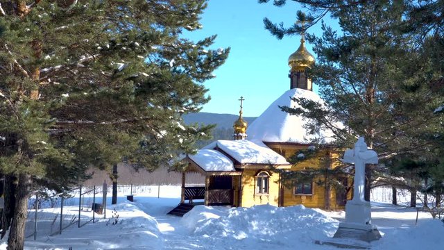 A small church is in the forest. Beautiful sunny day in winter.