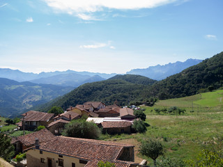 Fototapeta na wymiar Paisaje verde rural, con casas de pueblo típicas vistas desde el mirador de Piedras Luengas en Asturias, verano de 2018