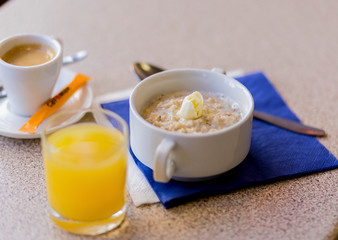 oatmeal on a blue background with orange juice and coffee