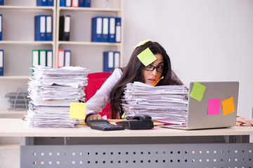 Young female employee in conflicting priorities concept 
