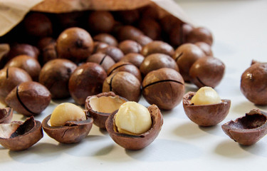 Organic macadamia nuts in craft bag on white table 