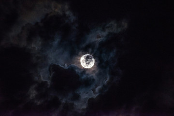Moon through the clouds at night, super moon