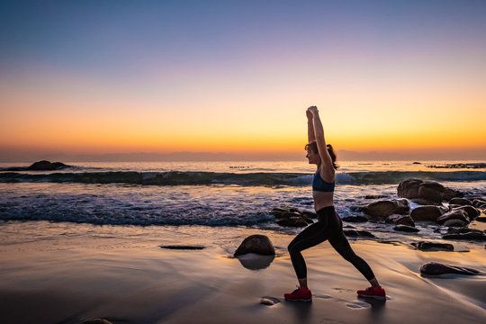 female athlete doing yoga on a beach