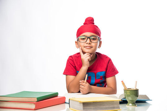 Small Indian/sikh Boy Studying At Study Table With Books