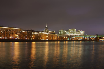 Fototapeta na wymiar Moskva River, its embankment and Andreevsky (Pushkinsky) pedestrian bridge in the lights reflections at spring night time. Long exposure image.