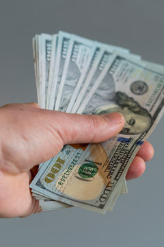 Hand with dollars on a gray background. dollars money finance currency in hand on gray background. vertical photo