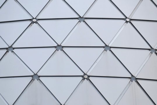 Close up a glass surface of a triangle pattern inside a high building in the city