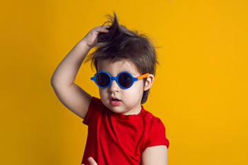 cheerful baby boy in red t-shirt stands