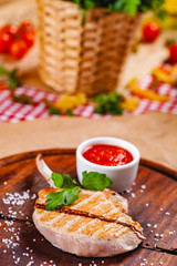 Rack of lamb with tomato sauce on wooden cutting board. Close up