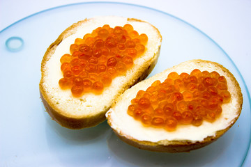 Fototapeta na wymiar Red caviar on sandwiches on the white background