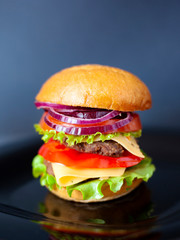 juicy burger with two pork cutlets and fresh vegetables; It consists of: buns, sweet sweet sauce, onion, pepper, tomatoes, green salad and cheese