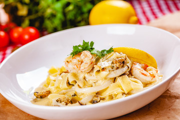 Italian pasta with seafood on white plate. Close up